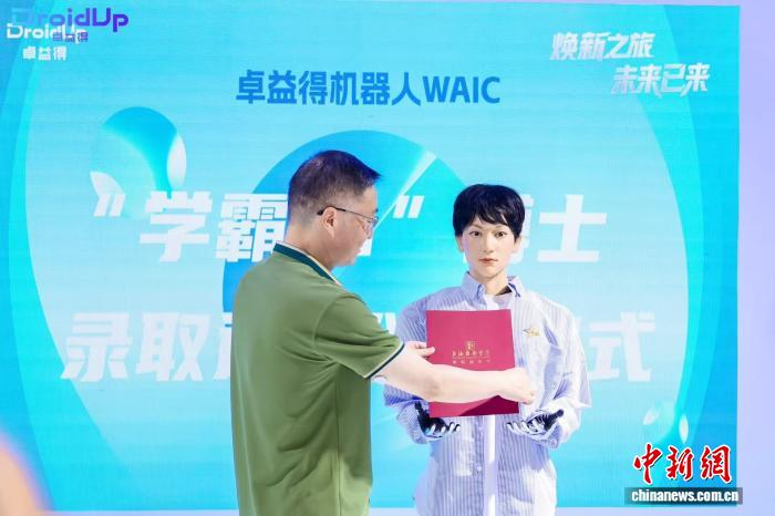 7月27日、ロボット「學(xué)覇01」に博士課程の合格通知書を手渡す上海戯劇學(xué)院の謝巍黨委書記。（撮影?佳奇）