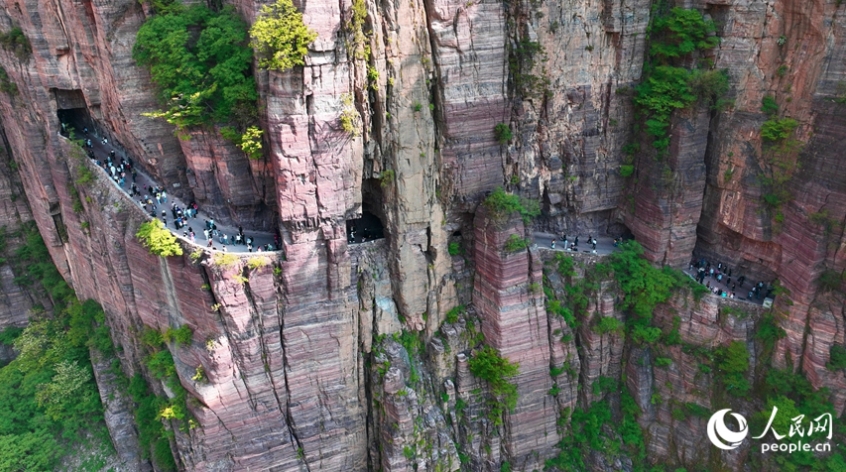 高さ100メートルの斷崖絶壁に作られた「回廊」。観光のオンシーズンを迎え、多くの観光客で賑わっている。（撮影?宋芳鑫）