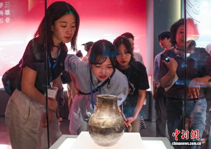 青海省西寧市大通回族土（トゥ）族自治県で出土したペルシアの銀製壺（複製）を見學(xué)する創(chuàng)価大學(xué)の學(xué)生（撮影?馬銘言）。