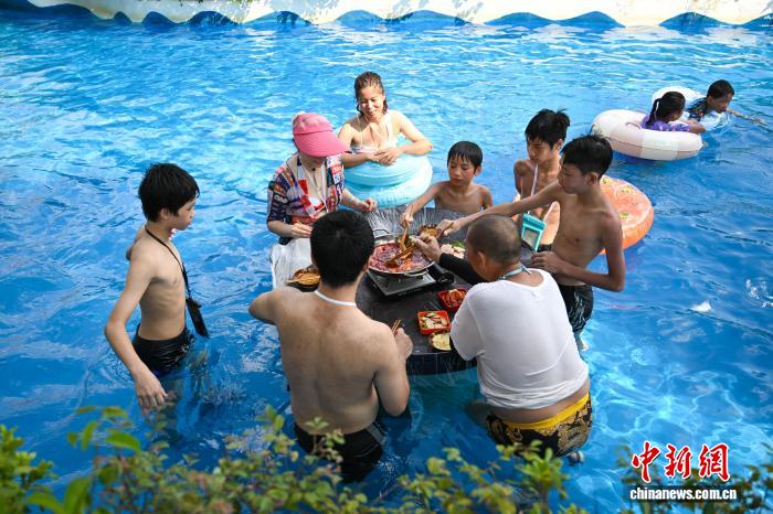 重慶市美心紅酒小鎮(zhèn)ウォーターパークで、水に浸かりながら火鍋を楽しむ人々（8月2日撮影?何蓬磊）。