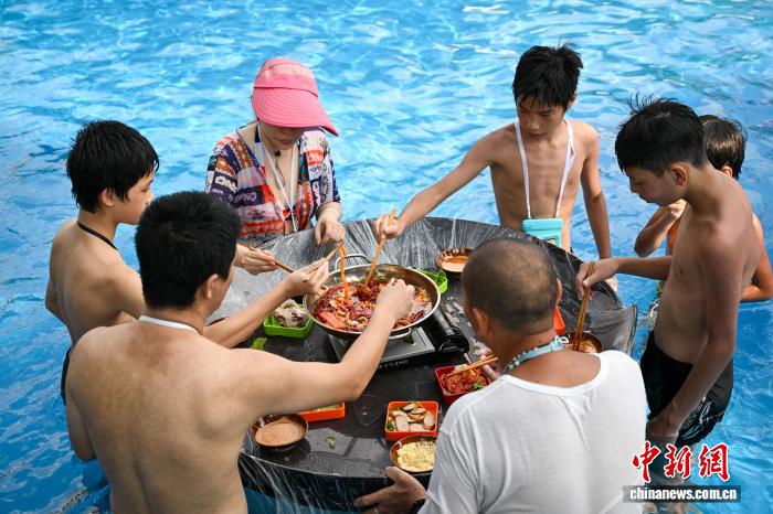 波のプールや水に浸かって火鍋を楽しむ重慶の人々