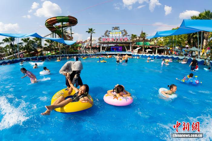 波のプールや水に浸かって火鍋を楽しむ重慶の人々