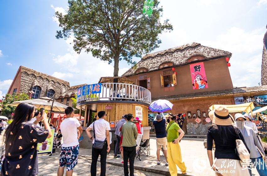 海坪彝族の特色ある観光リゾートタウンでパフォーマンスを見(jiàn)る観光客たち（撮影?涂敏）。