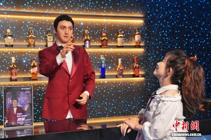 8月8日、北京初のロボットテーマレストラン「ロボット焔究所」が正式に営業(yè)を開始。バーテンダーロボットと客の交流の様子。（撮影?張祥毅）