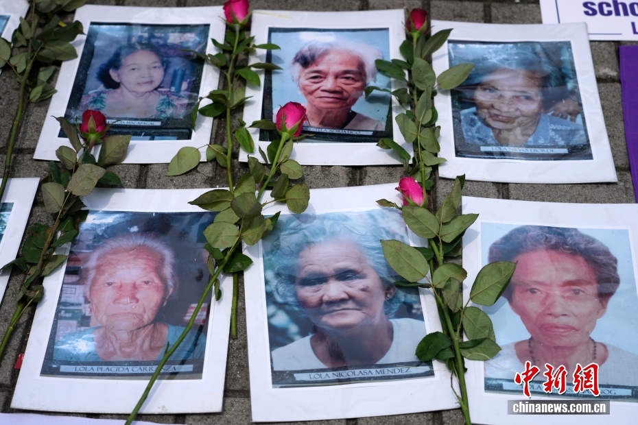 地面に整然と並べられ、花が捧げられたすでに故人となった「慰安婦」たちの寫真（撮影?張興龍）。