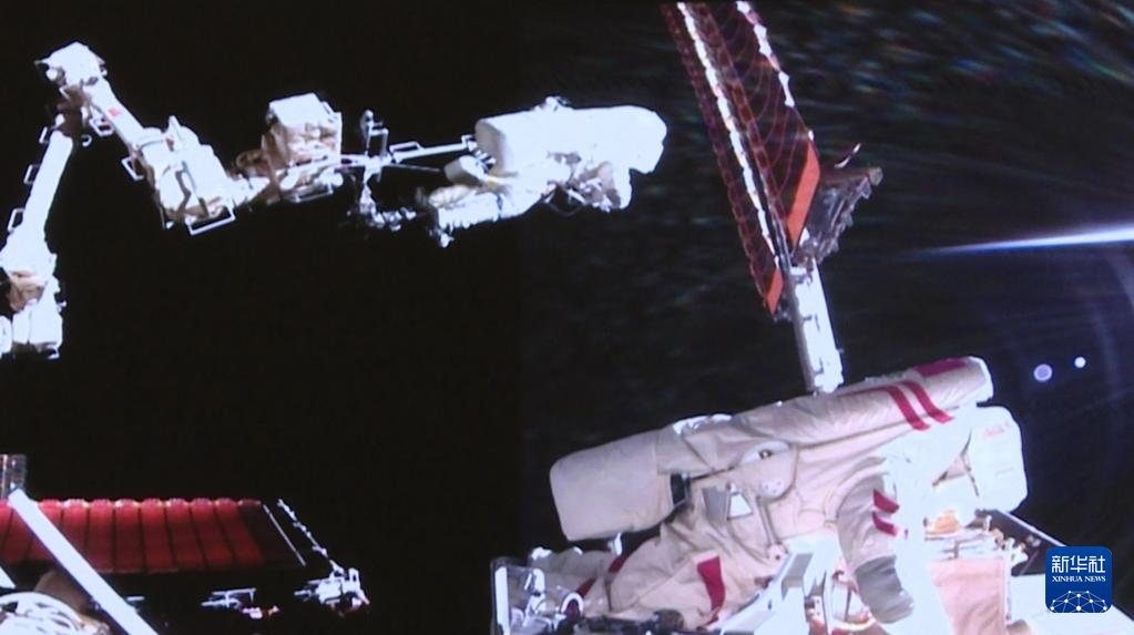 これは8月15日、北京宇宙飛行制御センターのスクリーンに映し出された、「神舟20號(hào)」の宇宙飛行士チームの陳冬氏（左）と王傑氏が船外で作業(yè)する様子（映像のスクリーンショット）。撮影?殷家捷