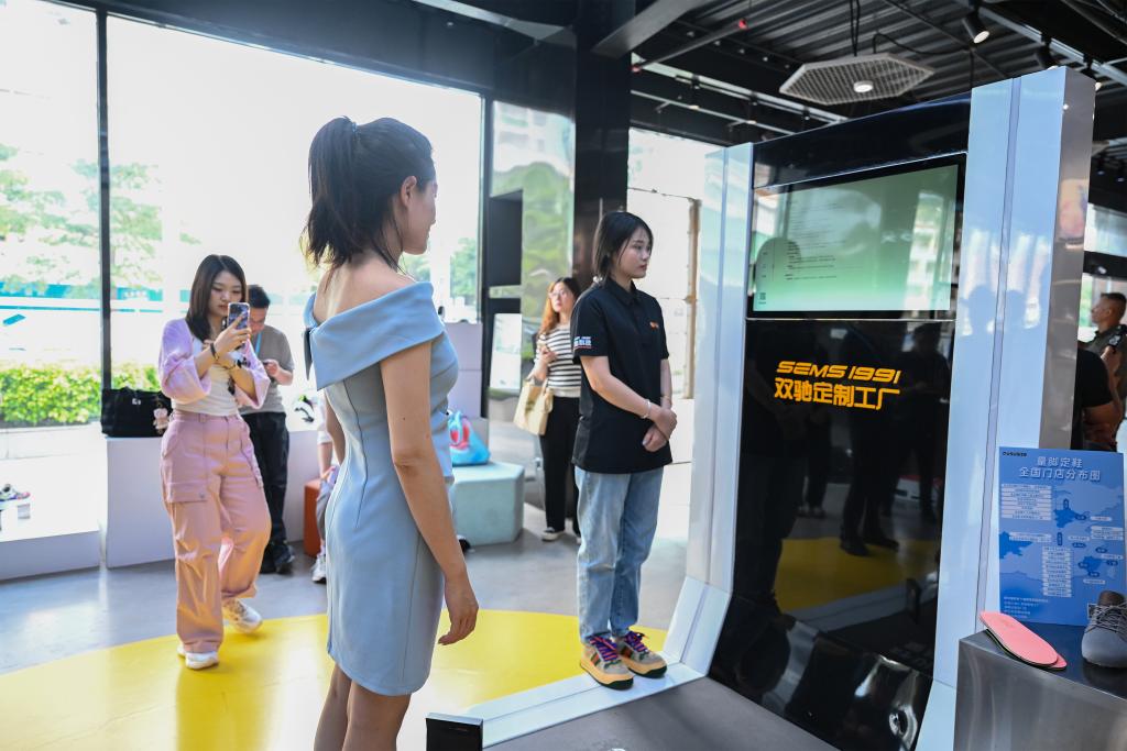 8月19日、福建省莆田市の雙馳科技カスタム工場直営店で、足型データを採取する機(jī)器を體験する消費(fèi)者。撮影?周義