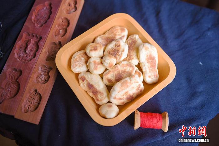 趙金蓉さんが作った巧果。山東省の膠東地區(qū)では、舊暦の7月7日に巧果を赤い糸でつなぐ風習があり、それには牛飼いの牛郎と機織りの少女?織女を赤い糸で結びつけるという願いが込められている（撮影?王嬌妮）。