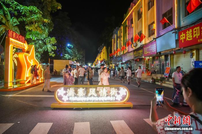 夜の散策を楽しむ市民や観光客でにぎわう最近オープンしたばかりの広西憑祥市の浦寨風(fēng)情街（8月27日撮影?陳冠言）。