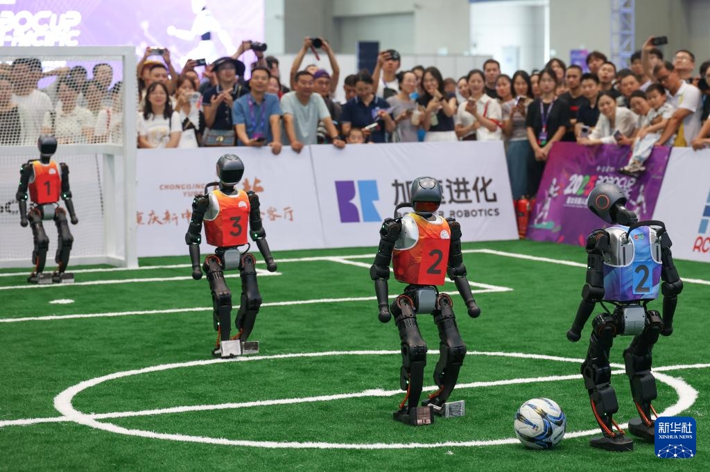 2025世界スマート産業(yè)博覧會(huì)でサッカーをする人型ロボットを見る來場(chǎng)者（9月5日撮影?陳誠）。