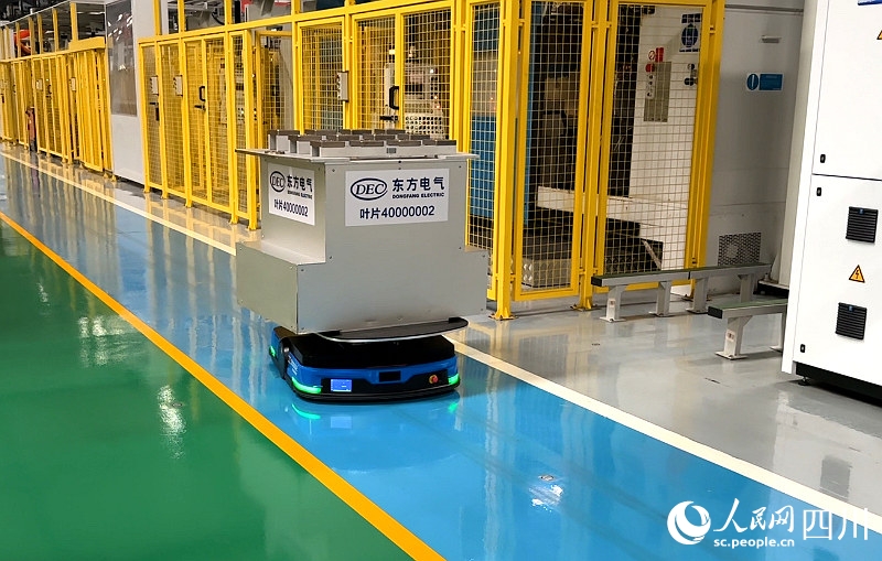 工場內(nèi)で自分よりも何倍も大きい加工待ちの材料を運(yùn)ぶ無人搬送車（AGV、撮影?張?jiān)剑?></p>
<p style=