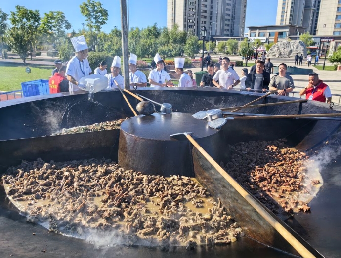 グルメエリアの大きな鉄鍋で煮込んだガチョウ料理（撮影?王君寶）。