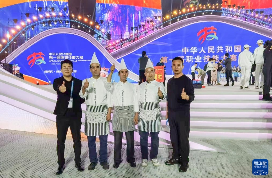 第1回全國技能大會(huì)「中華絶技」の會(huì)場(chǎng)で、実演ゲストとして參加したあと、記念寫真を撮影する熱西堤さん（資料寫真、寫真提供?庫車市融メディアセンター）。