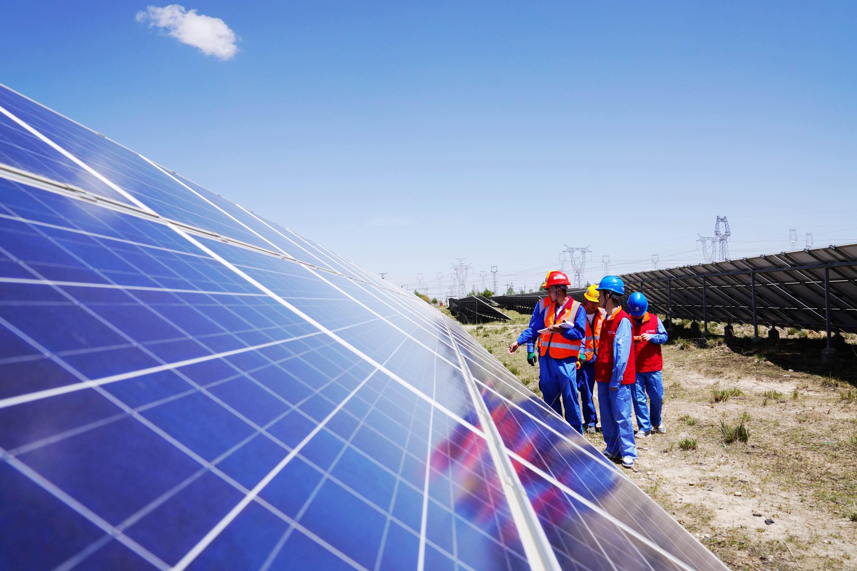 青海省海南蔵（チベット）族自治州の1000萬kW級再生可能エネルギー拠點の太陽光発電産業(yè)パークで企業(yè)の電気設(shè)備の稼働狀況を點検する國網(wǎng)青海省電力公司の職員。撮影?徐琛