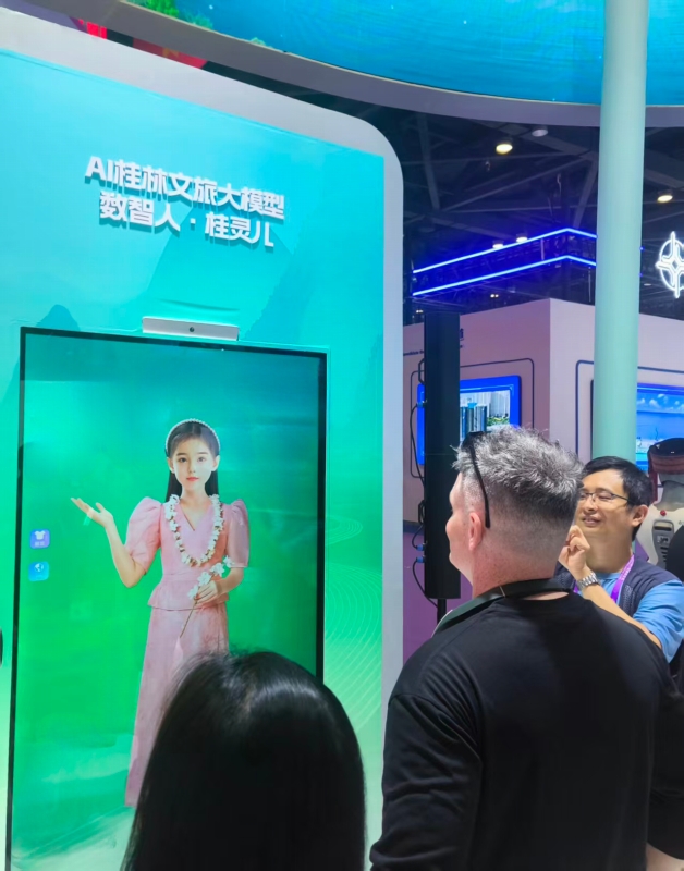 デジタルヒューマン「桂霊児」を見る來場者ら。