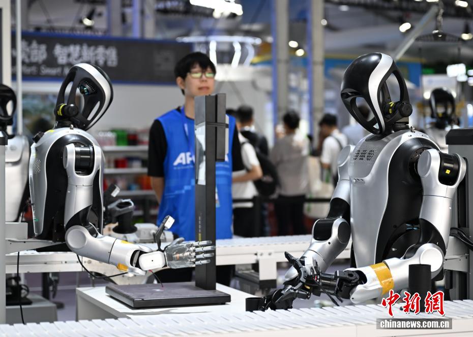 生産ラインで働くデモンストレーションを行う2臺の産業(yè)用ロボット（9月24日撮影?王剛）。