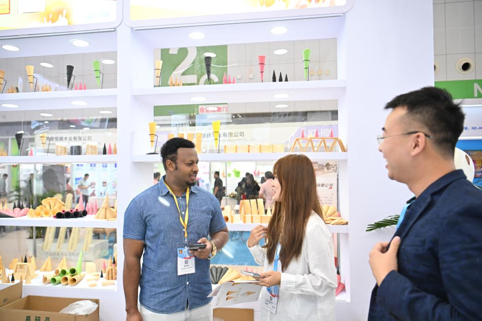 天津梅江國(guó)際エキシビションセンターでエチオピアから來(lái)た貿(mào)易業(yè)者と商談する出展企業(yè)の女性スタッフ（9月24日撮影?孫凡越）。