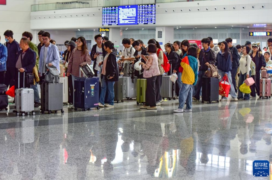 安徽省の阜陽西駅の待合ホールに並んで改札を待つ乗客（10月8日撮影?盧啓建）。