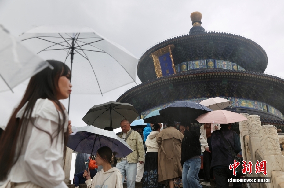 北京の天壇公園で、雨の降る中散策する來園客（10月8日撮影?易海菲）。