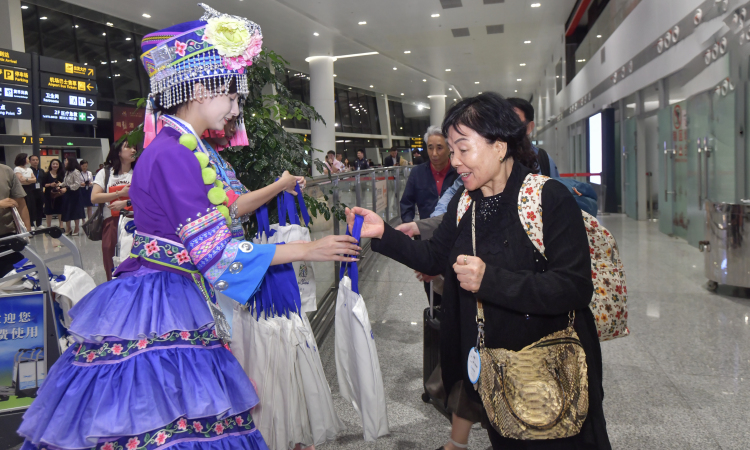 ソウルと桂林を往復(fù)する國(guó)際線の運(yùn)航再開を祝う桂林のうちわを乗客に配るスタッフ。
