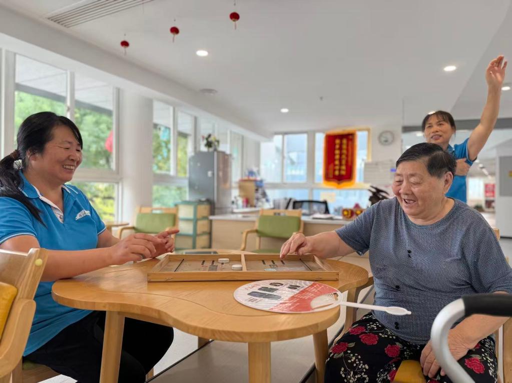 高齢者とゲームをする杭州浜康楽齢センターのスタッフ（撮影?唐弢）。