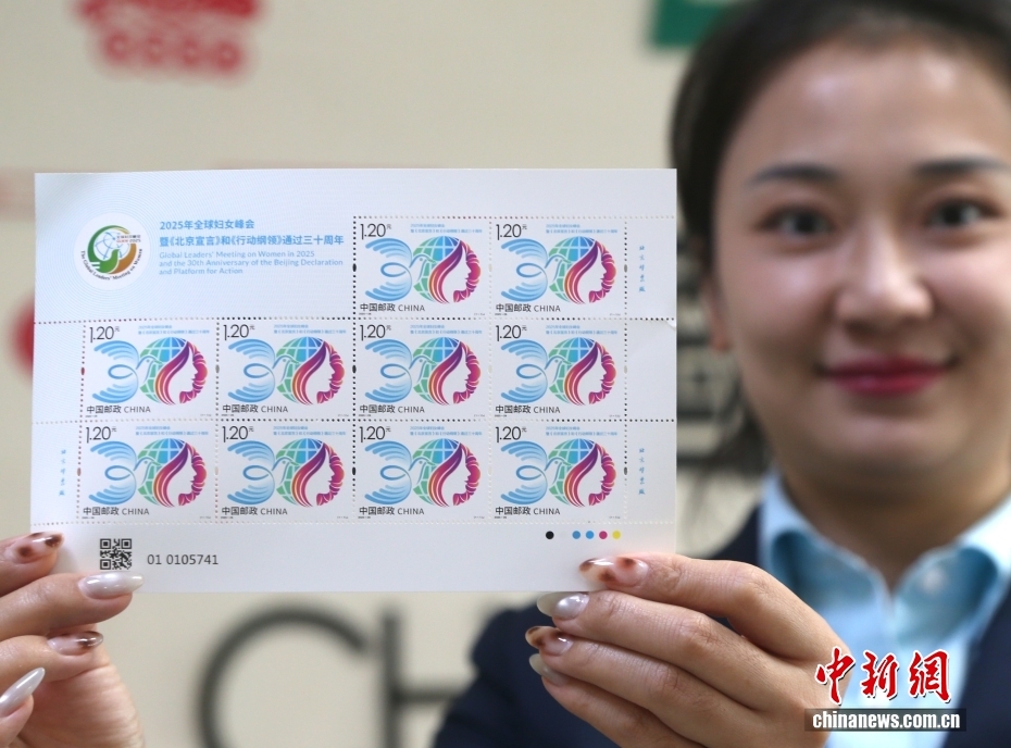 記念切手を見(jiàn)せる中國(guó)郵政集団有限公司青海省西寧市城西區(qū)黃河路の切手販売窓口の職員（撮影?張忠蘋(píng)）。