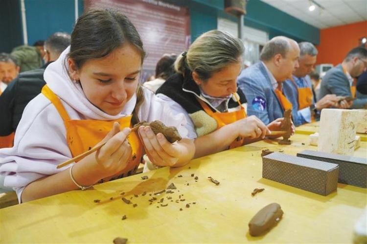 ベラルーシからの観光客のナドゼヤさん（寫真一番左側(cè)）と母親のアンジェラさん（寫真左から2人目）が兵馬俑のレプリカを作っている様子（資料寫真/撮影?王三合）。