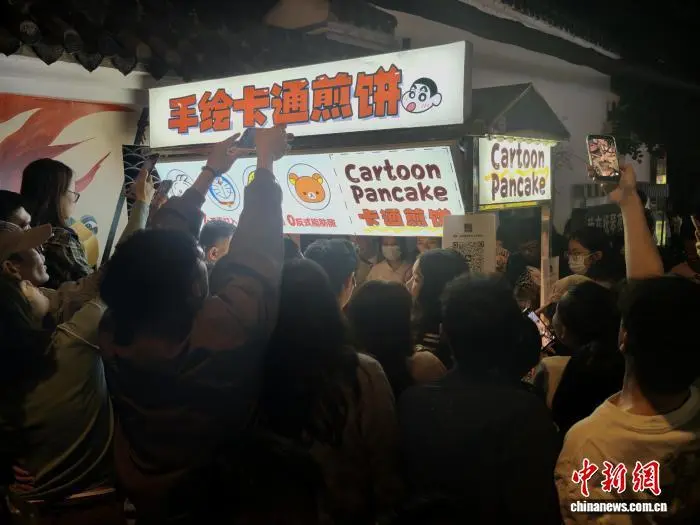 買物客と観光客でごった返すカートゥーンパンケーキの屋臺(tái)（撮影?呂楊）。