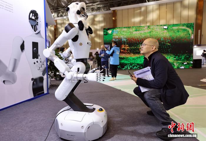 具身型大規(guī)模モデルロボット「Galbot G1」を見學(xué)する來(lái)場(chǎng)者（撮影?王磊）。