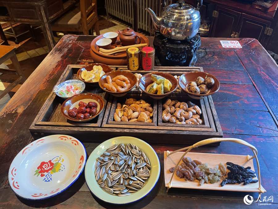 中國式アフタヌーンティーのセット。お茶請けはナッツ類や各種タネ?。ù橛?勝又あや子）