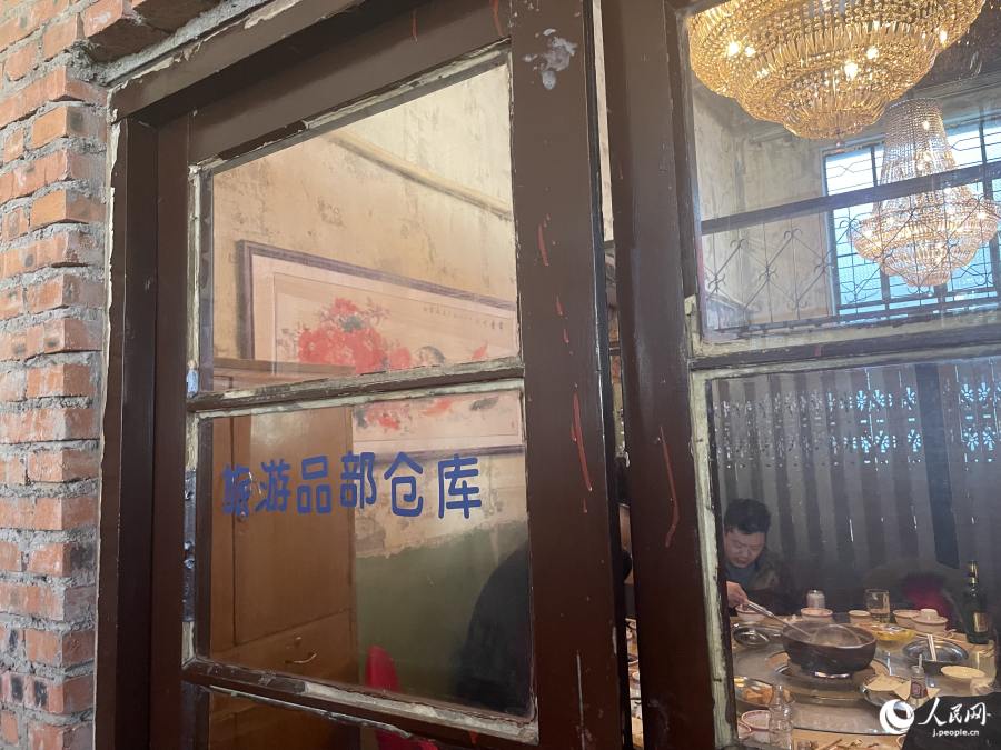 「旅遊品部倉庫」と書かれたガラス扉?！嘎眠[」は旅行?観光という意味（撮影?勝又あや子）