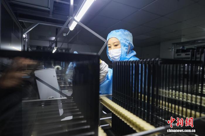 タブレット用タッチスクリーンカバーガラスの完成品を検査する検査員（撮影?瞿宏倫）。