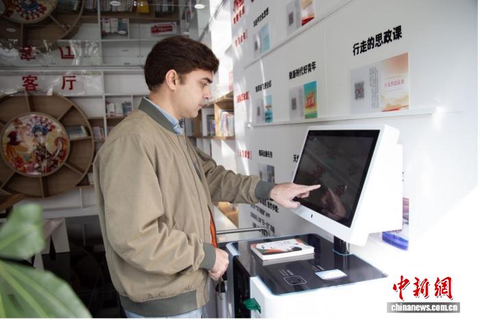 社會(huì)保障カードを使ってスマート図書(shū)館で本を借りる外國(guó)人男性（寫(xiě)真提供：重慶市人的資源社會(huì)保障局）。