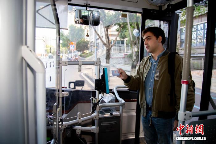 社會(huì)保障カードを使って路線バスに乗る外國(guó)人男性（寫(xiě)真提供：重慶市人的資源社會(huì)保障局）。