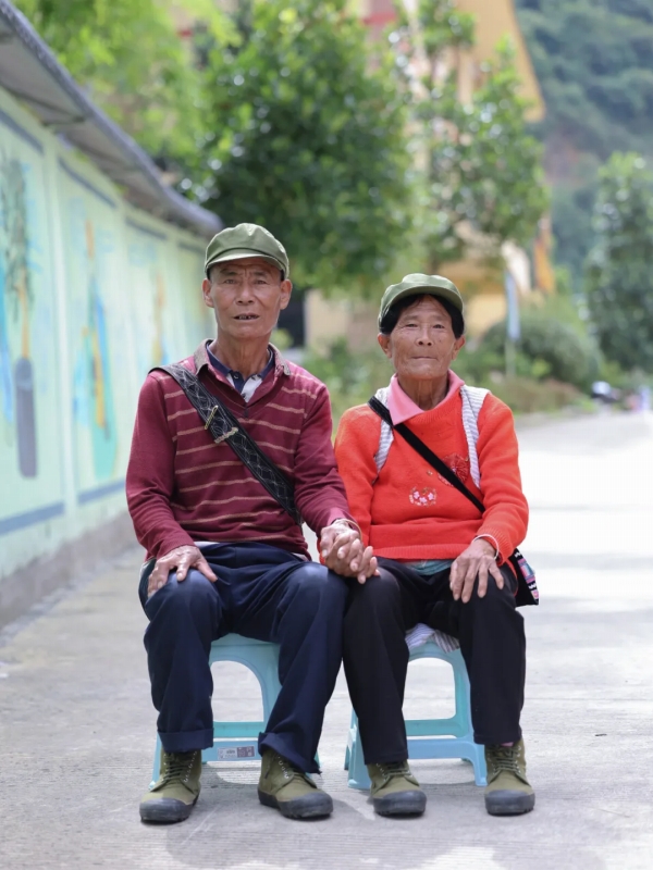 恥ずかしそうに妻の手を握り寫真を撮影する相付益さん。