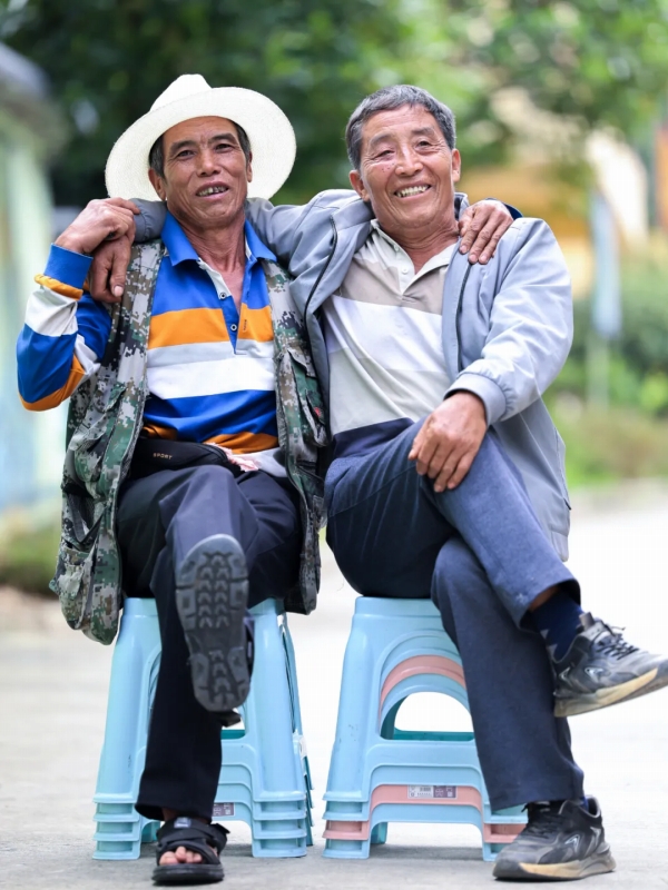 肩を組んで寫真を撮影する恒鄧乃さん（寫真左）と光付三さん。