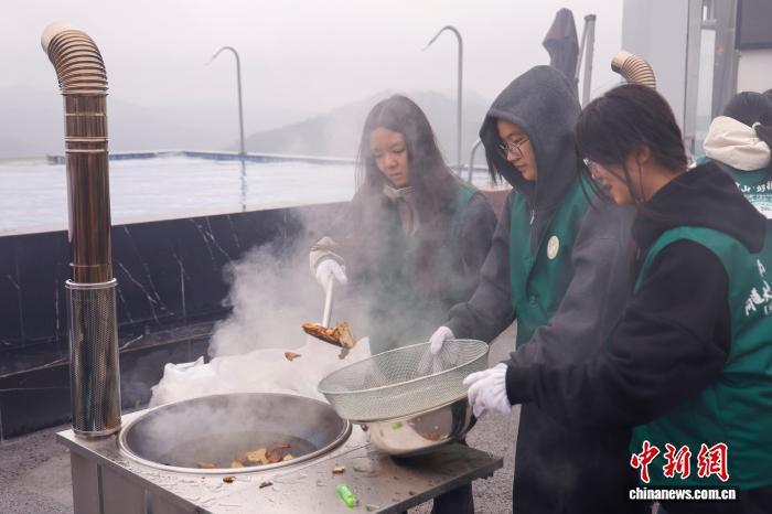 生薬の「白朮」を炒って加工する學(xué)生（撮影?肖健）