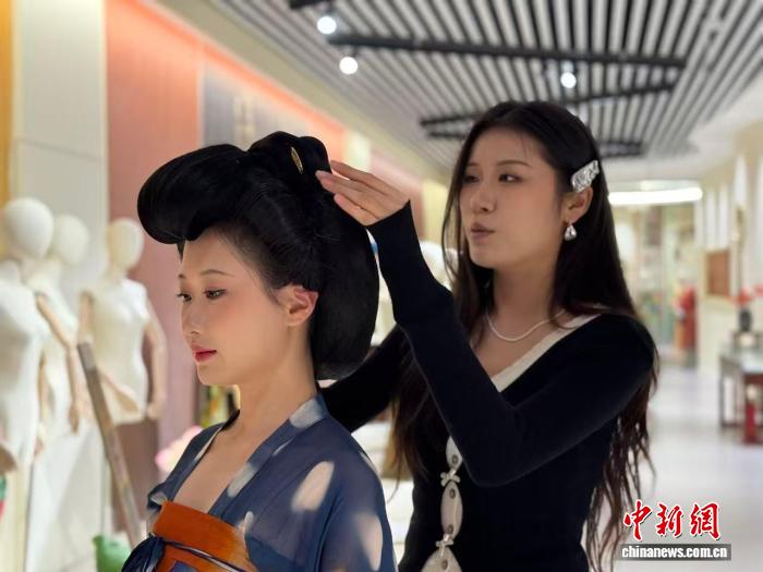 漢服を著た人のヘアを整える王依婷さん（右）。（撮影?楊英琦）