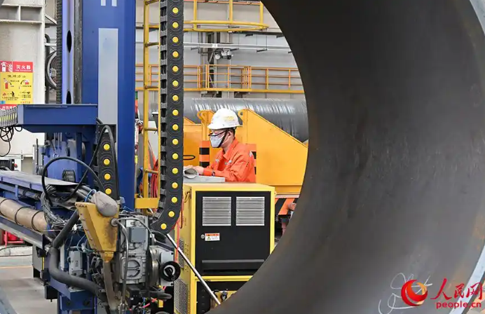 海油工程天津スマート製造拠點(diǎn)の構(gòu)造用パイプ製造工場(chǎng)では、スマート溶接裝置を操作している作業(yè)員（撮影?孫一凡）。