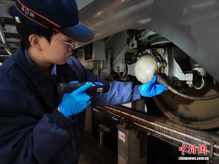 高速鉄道車両の検査で、弾力性を保つパテの狀態(tài)を確認(rèn)する作業(yè)員（撮影?李各）。