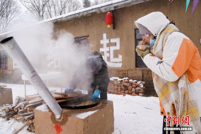黒竜江省鉄力市の透竜景勝地で、鉄鍋煮込みを味わう観光客（11月29日撮影?趙宇航）。