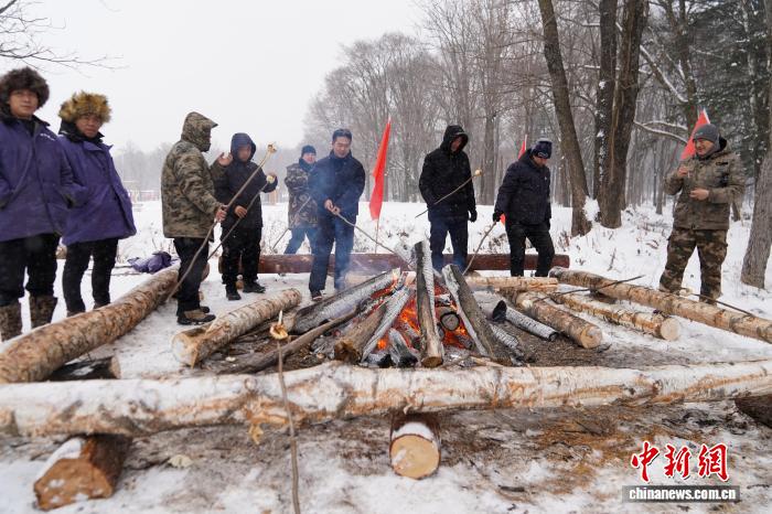 黒竜江省鉄力市の透竜景勝地で、焼き芋作りを體験する観光客（11月29日撮影?趙宇航）。