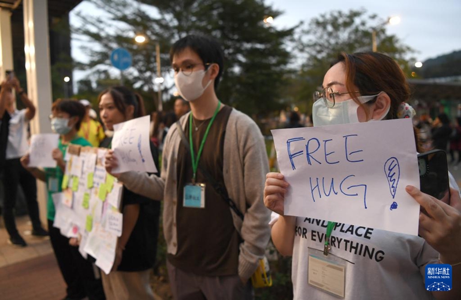 香港?大埔區(qū)の広福休憩処で、被災(zāi)者に心のケアを提供するために「フリーハグ」と書かれた紙を掲げるボランティアら（11月30日撮影?陳鐸）。