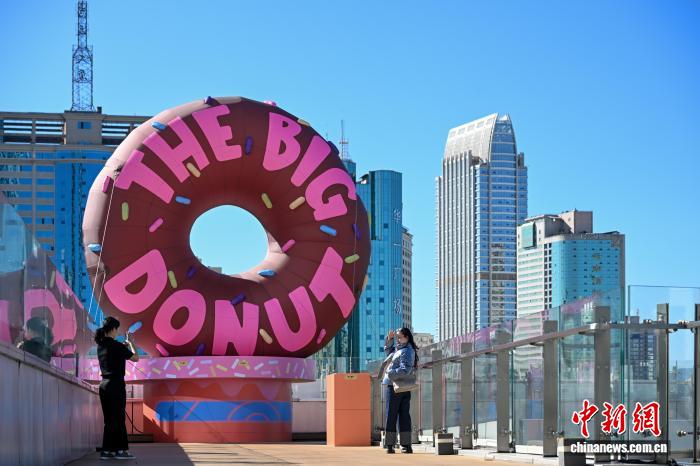 「ズートピア２」の巨大ドーナツ型インスタレーションの前で、寫真を撮影する市民（12月4日撮影?李嘉嫻）。