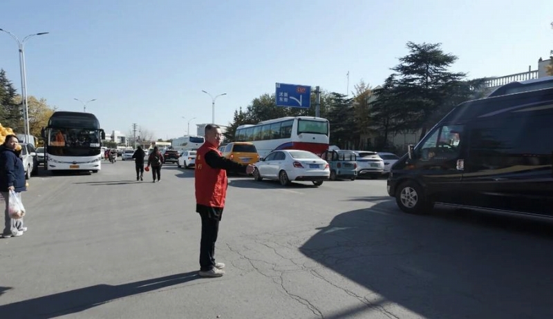 駐車場で車を誘導(dǎo)するボランティア。