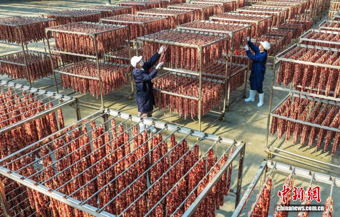 燻製肉や腸詰めを天日干しする作業(yè)員（12月9日、ドローンによる撮影?施亜磊）。