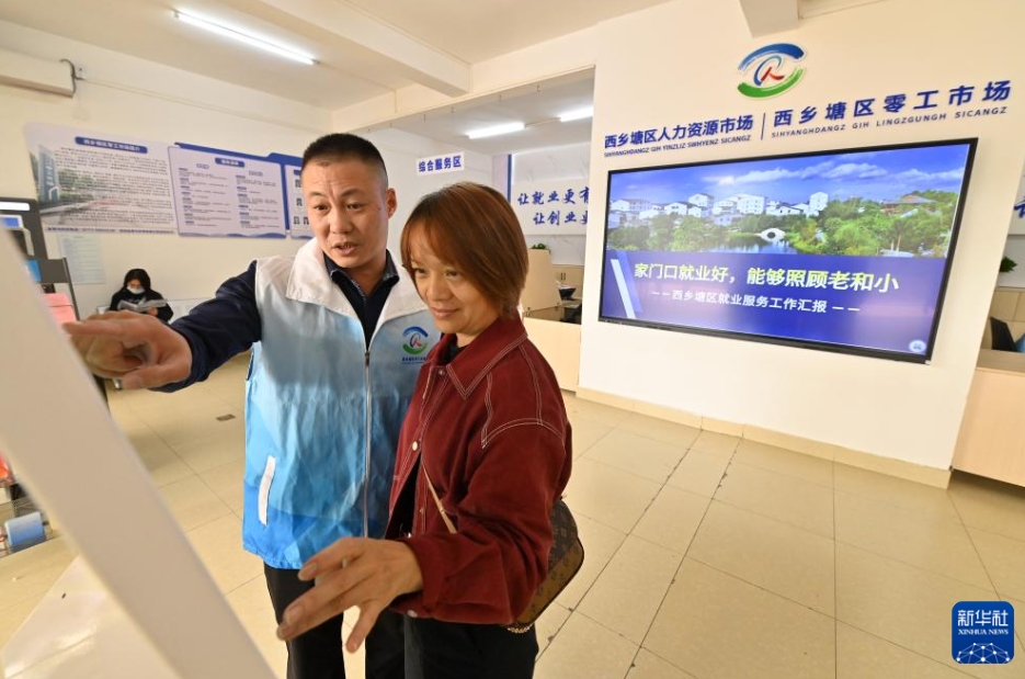 広西壯族自治區(qū)南寧市西郷塘區(qū)の非正規(guī)雇用市場(chǎng)で、求人情報(bào)の探し方を指導(dǎo)する職員（寫真左、12月10日撮影?陸波岸）。