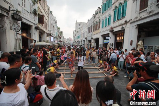 バンブーダンスを體験する観光客（撮影?馮恵）。