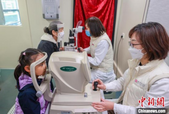 22日、「ライフライン?エクスプレス」で目の検査を行う中國(guó)人民解放軍総病院(301病院)の醫(yī)師たち（撮影?賈天勇）。