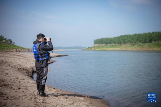 放流されたスナメリを望遠(yuǎn)鏡でチェックするスタッフ（4月25日撮影?伍志尊）。